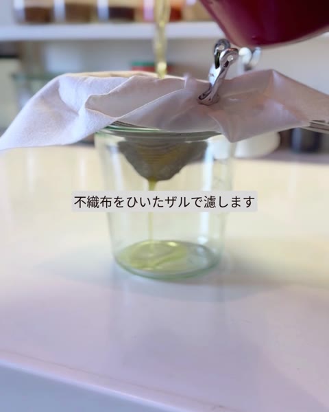 不織布を敷いたザルで、ガラス容器にギーを濾す